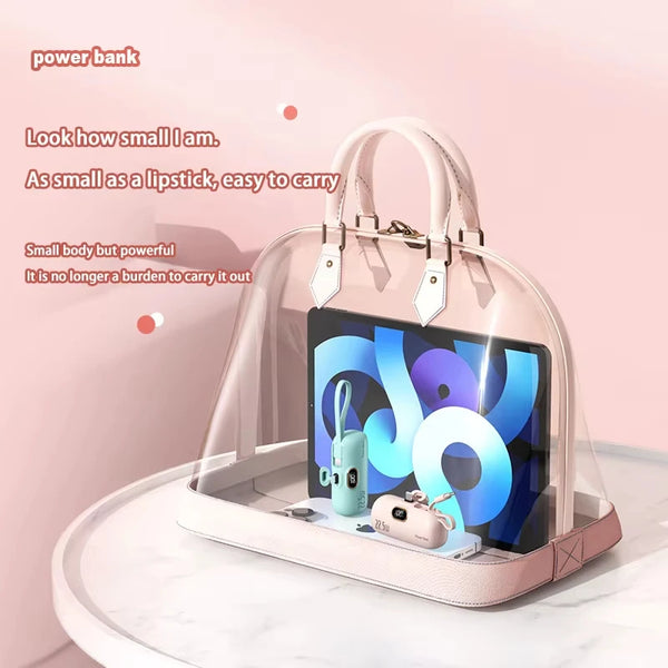 Clear handbag with electronic devices on a pink background
